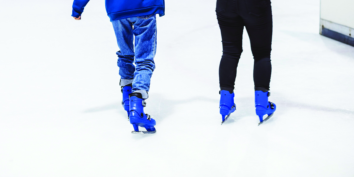 Two people skating on ice rink