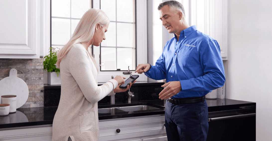 Culligan expert explaining how to use smart RO to a woman using her phone
